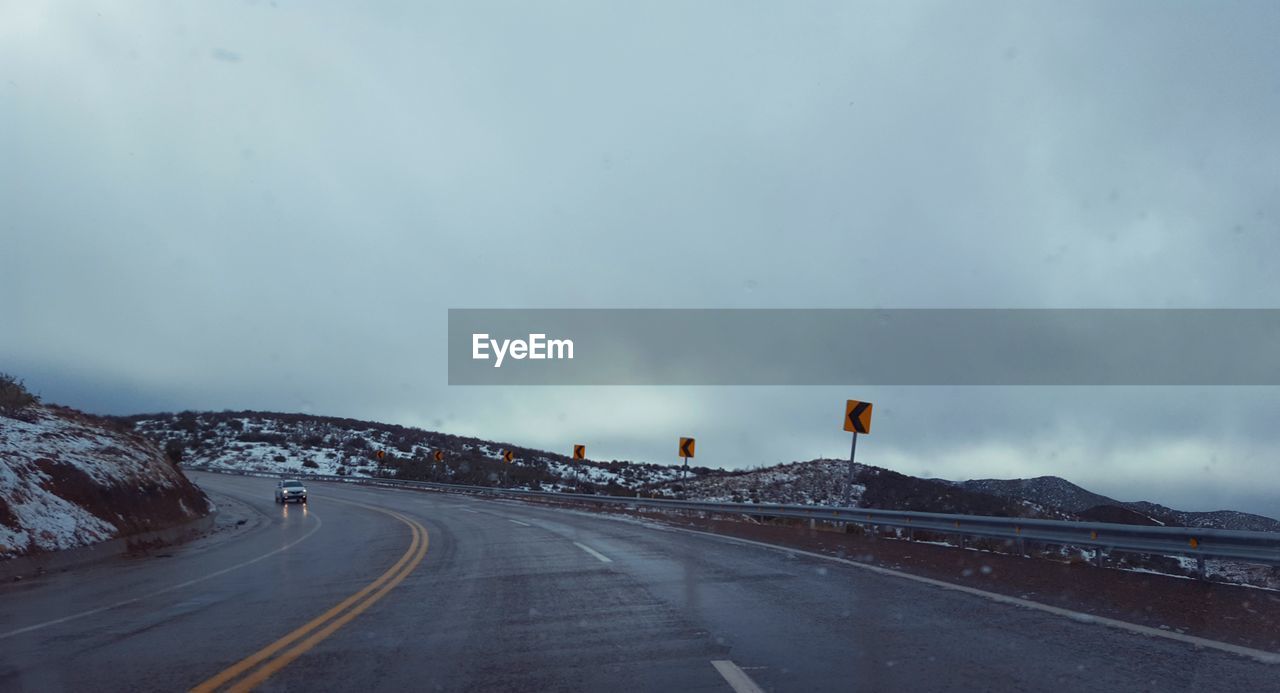 ROAD BY SNOW COVERED MOUNTAINS AGAINST SKY