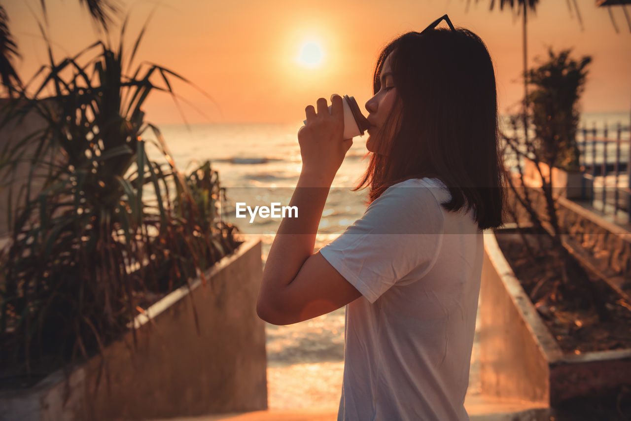 Woman drinking coffee at beach