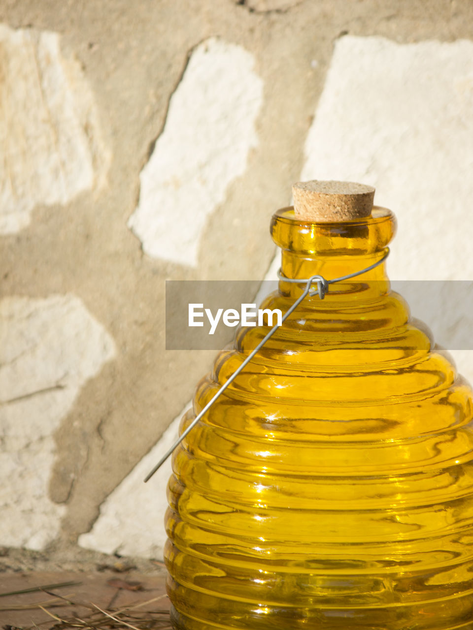 Close-up of yellow glass bottle against wall