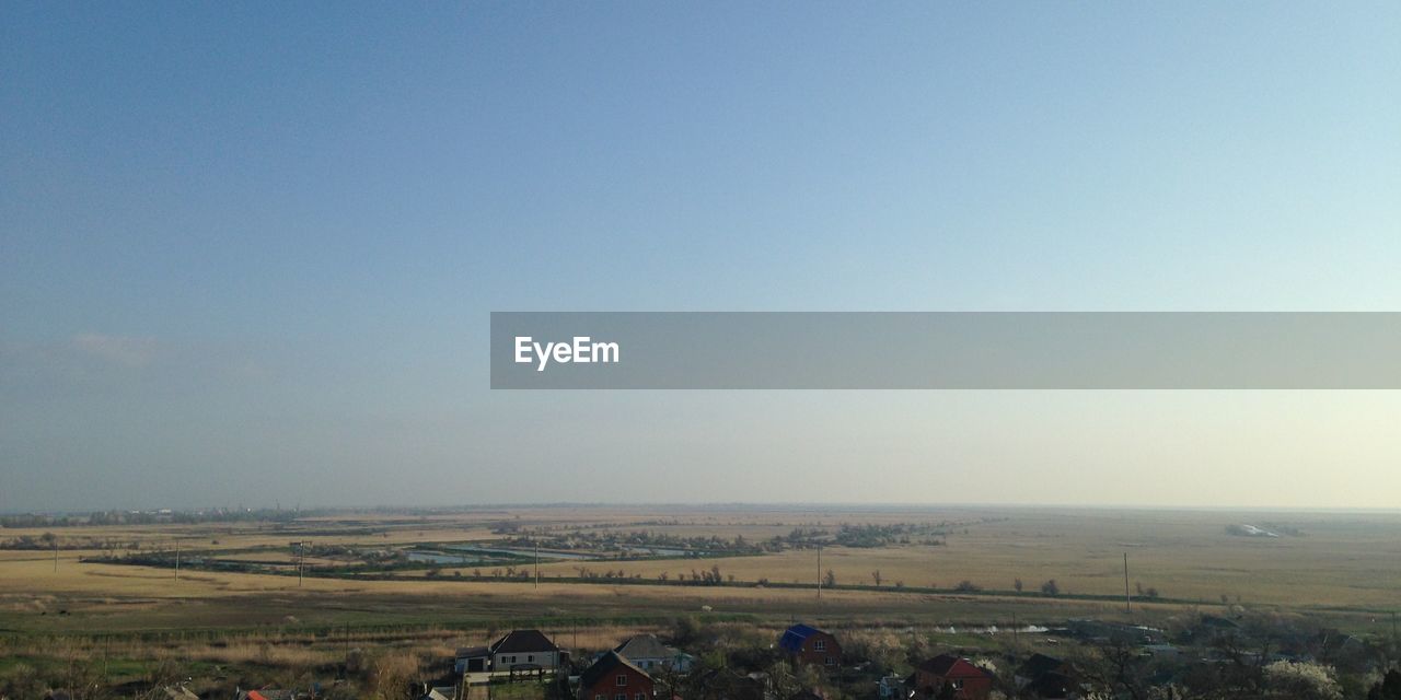 Scenic view of grassy field against blue sky