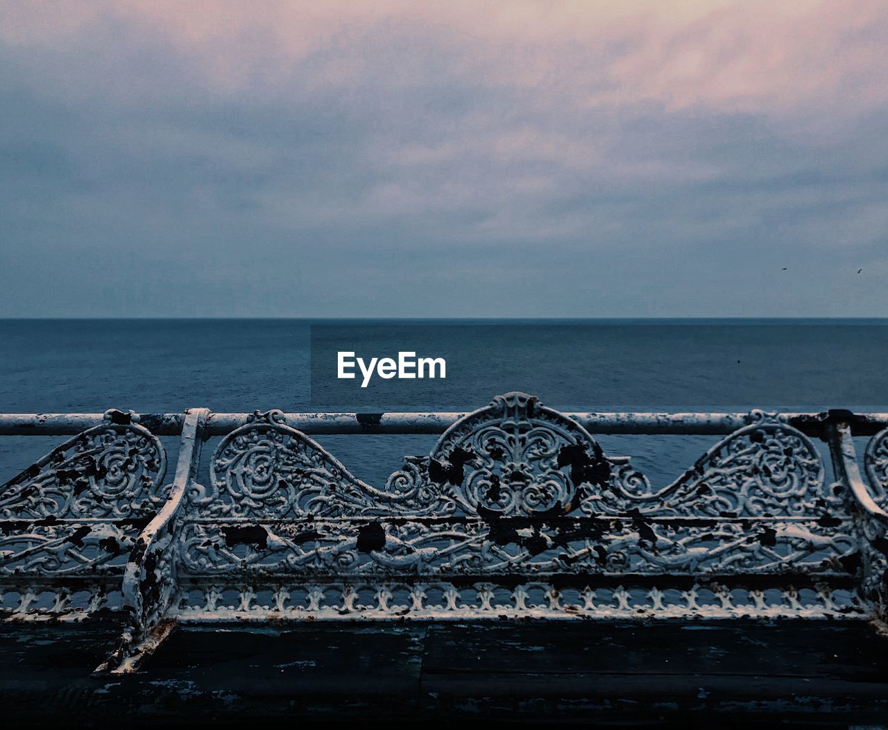 CLOSE-UP OF RAILING OVER SEA AGAINST SKY