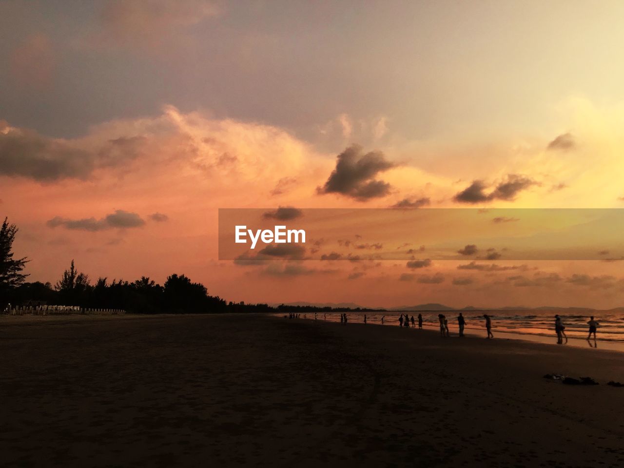 SCENIC VIEW OF BEACH AGAINST ORANGE SKY