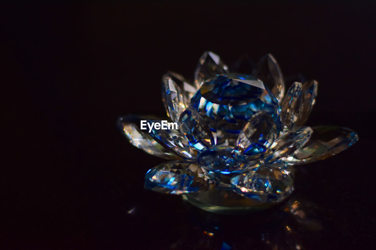 Close-up of crystal object over black background