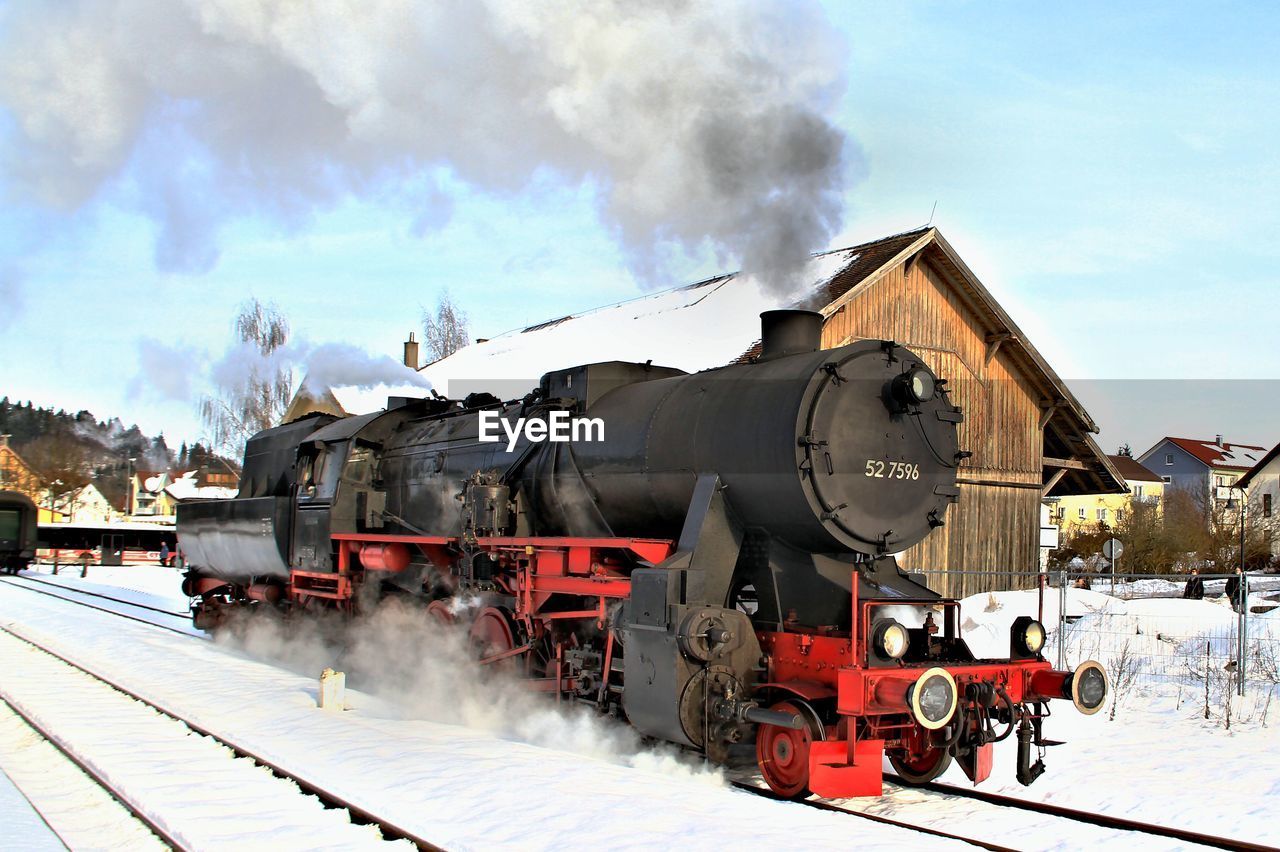 TRAIN ON RAILROAD TRACKS AGAINST SKY