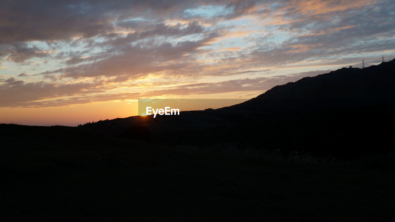 SILHOUETTE MOUNTAINS AGAINST SKY AT SUNSET