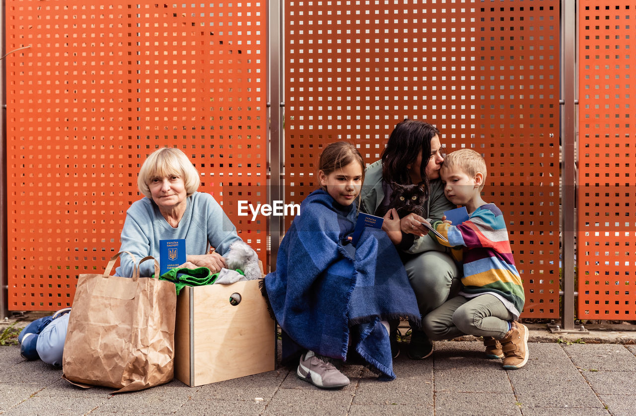 Family of ukrainian refugees with children and pet cat holding passports fleeing from ukraine 