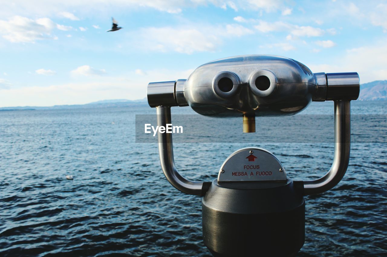 CLOSE-UP OF COIN-OPERATED BINOCULARS ON SEA