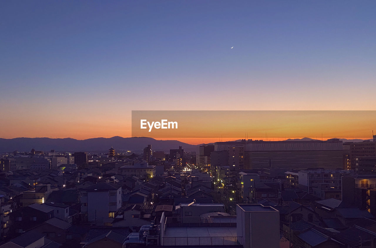 High angle view of illuminated buildings against sky during sunset