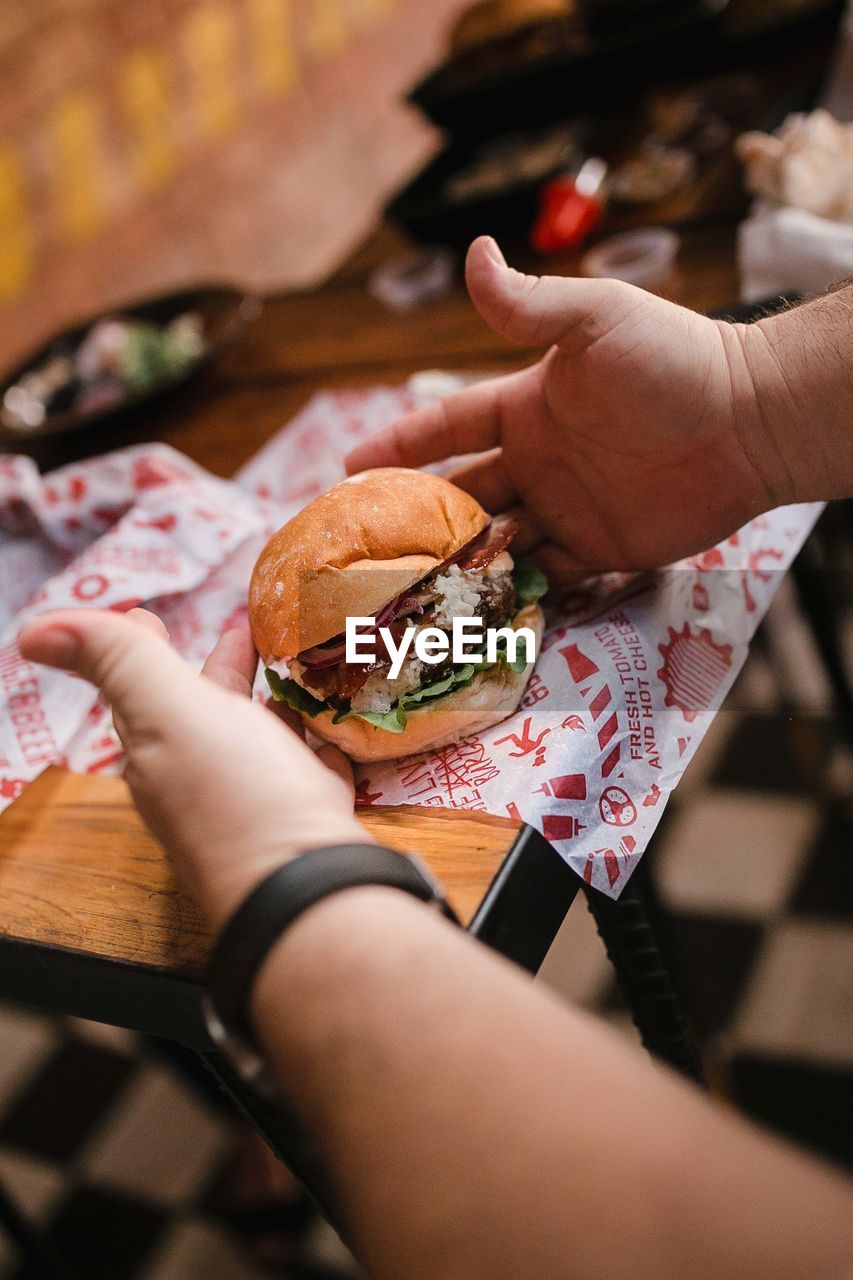 Close-up of hand preparing a burger