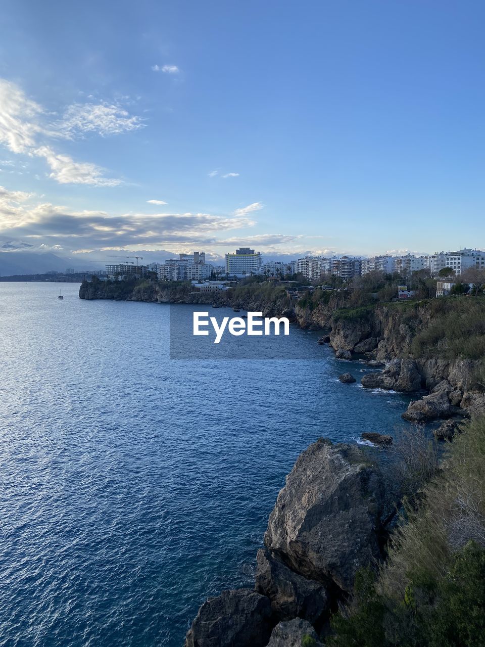 water, nature, blue, sea, beauty in nature, day, reflection, scenics - nature, sky, no people, terrain, outdoors, land, cliff, mountain, wave, beach, environment, motion, high angle view, tranquility, cloud, coast, sunlight, rock, travel, non-urban scene, ocean, ice