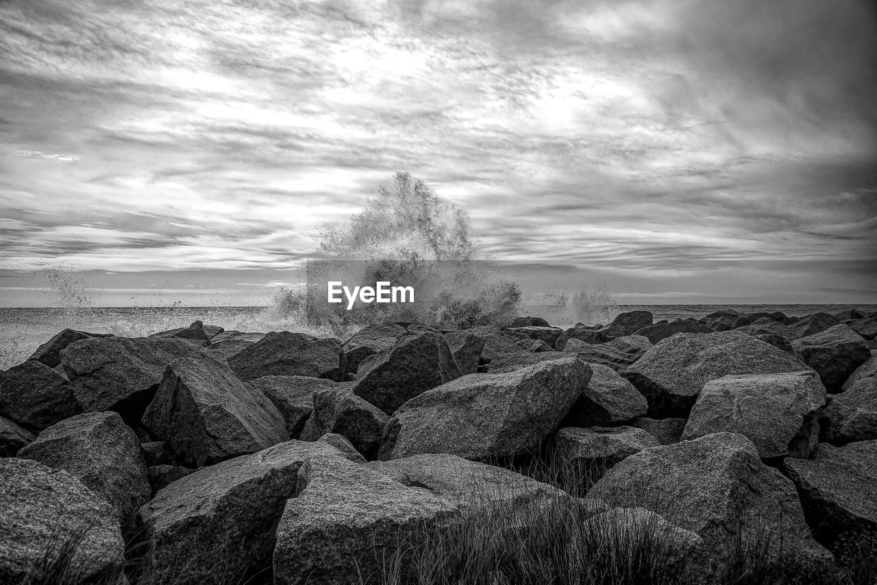 ROCKS ON SHORE AGAINST SKY