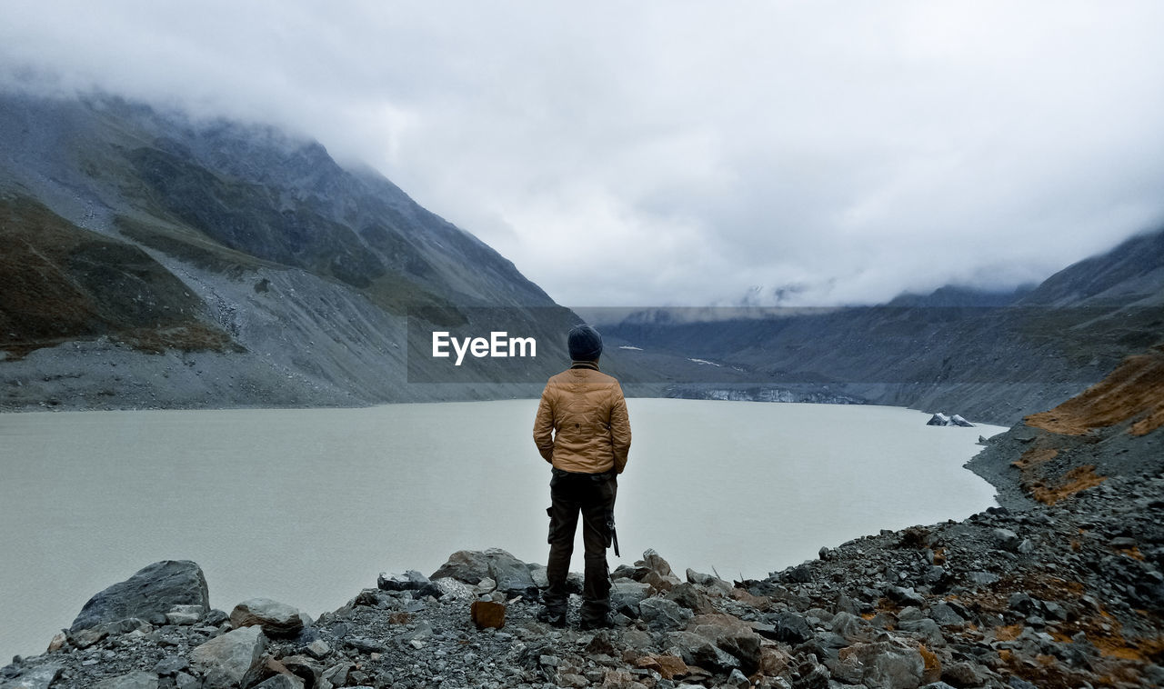 Rear view of woman standing on snowcapped mountain