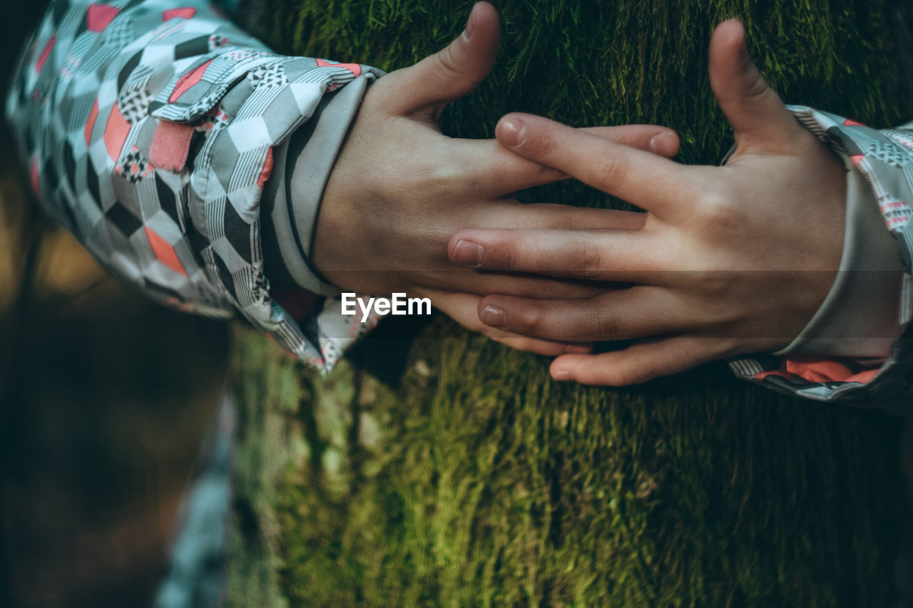 MIDSECTION OF COUPLE HANDS ON PLANT