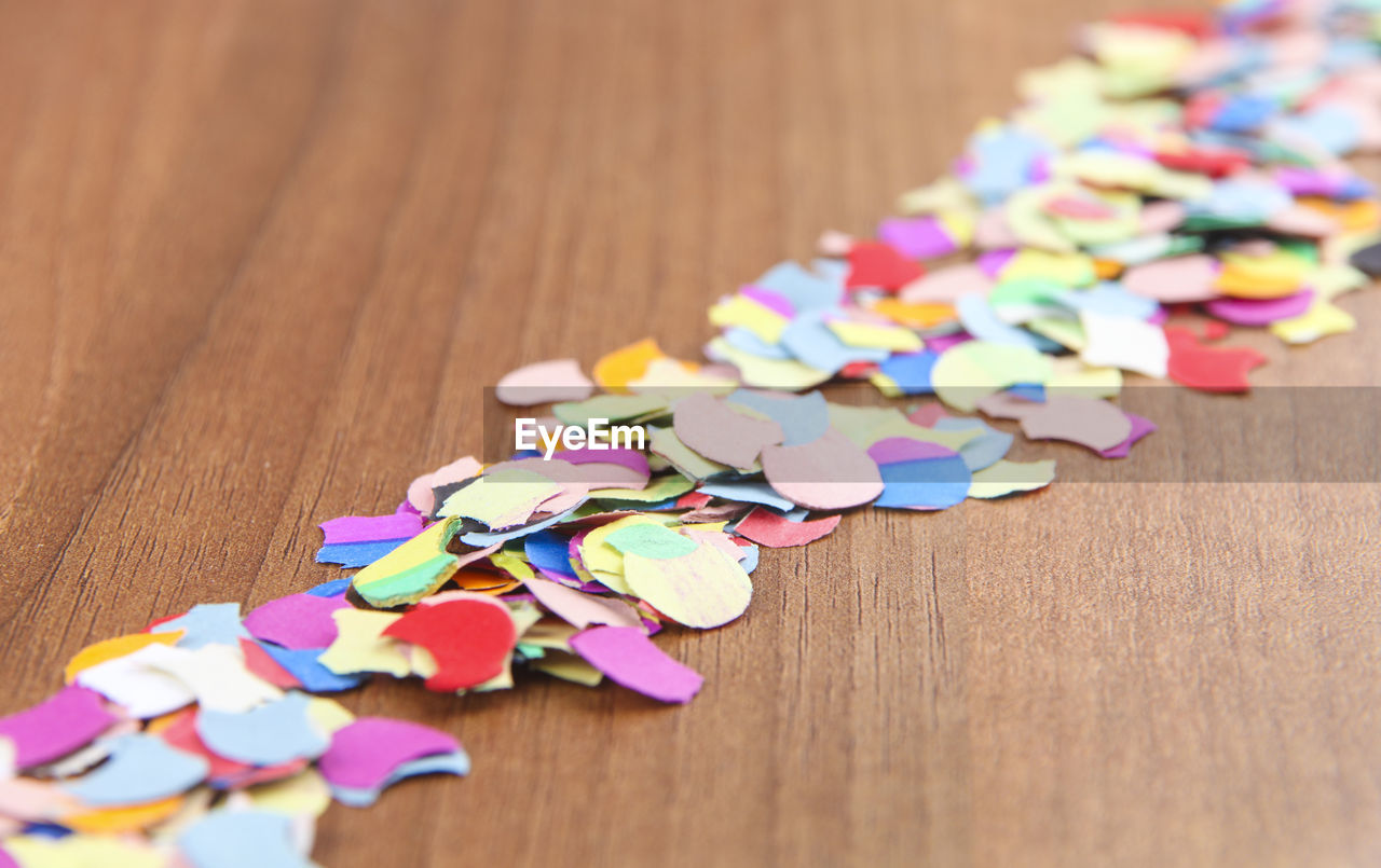 Close-up of multi colored confetti on table