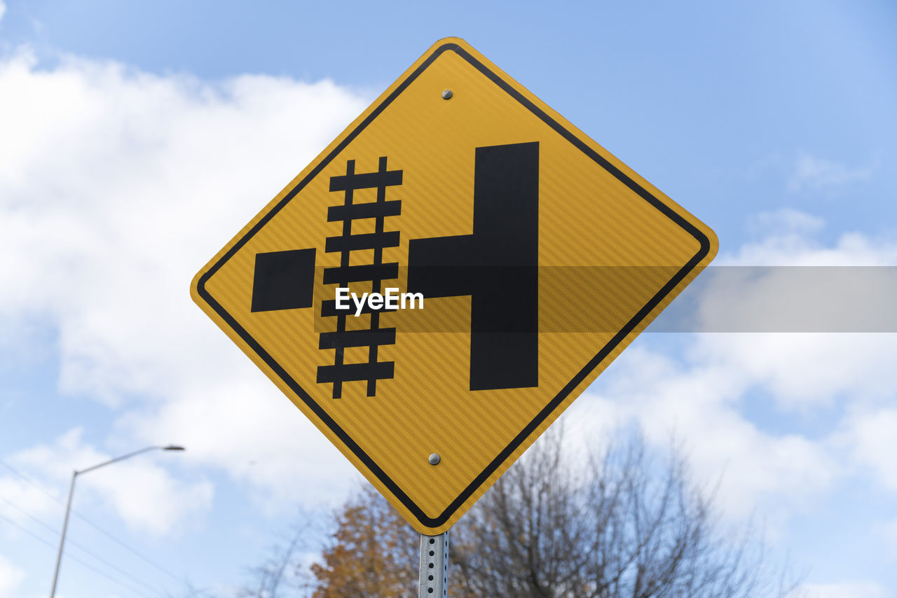 CLOSE-UP OF ROAD SIGN AGAINST SKY