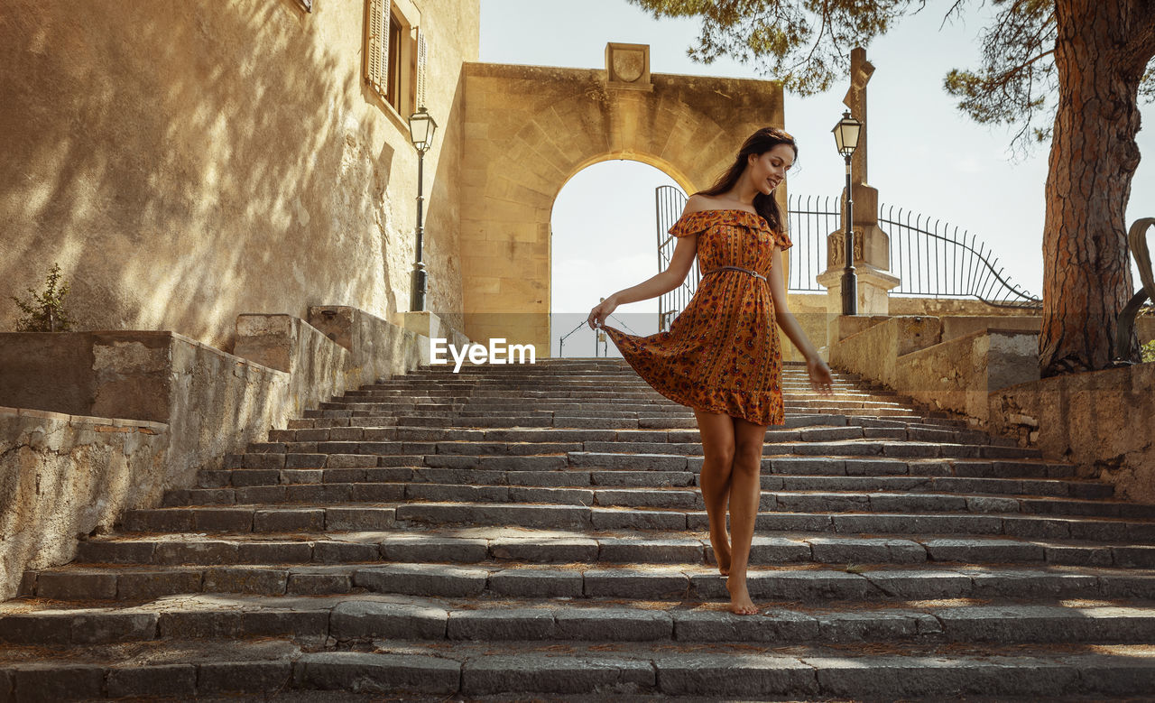 Low angle view of smiling woman walking on steps