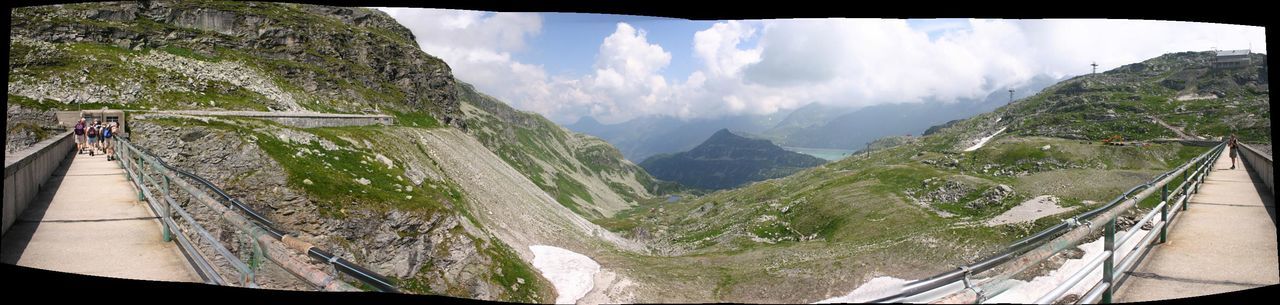 Panoramic view of bridge at mountains against cloudy sky