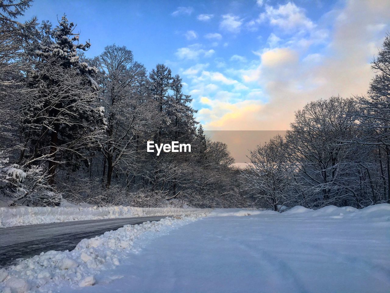 SNOW COVERED ROAD AGAINST SKY