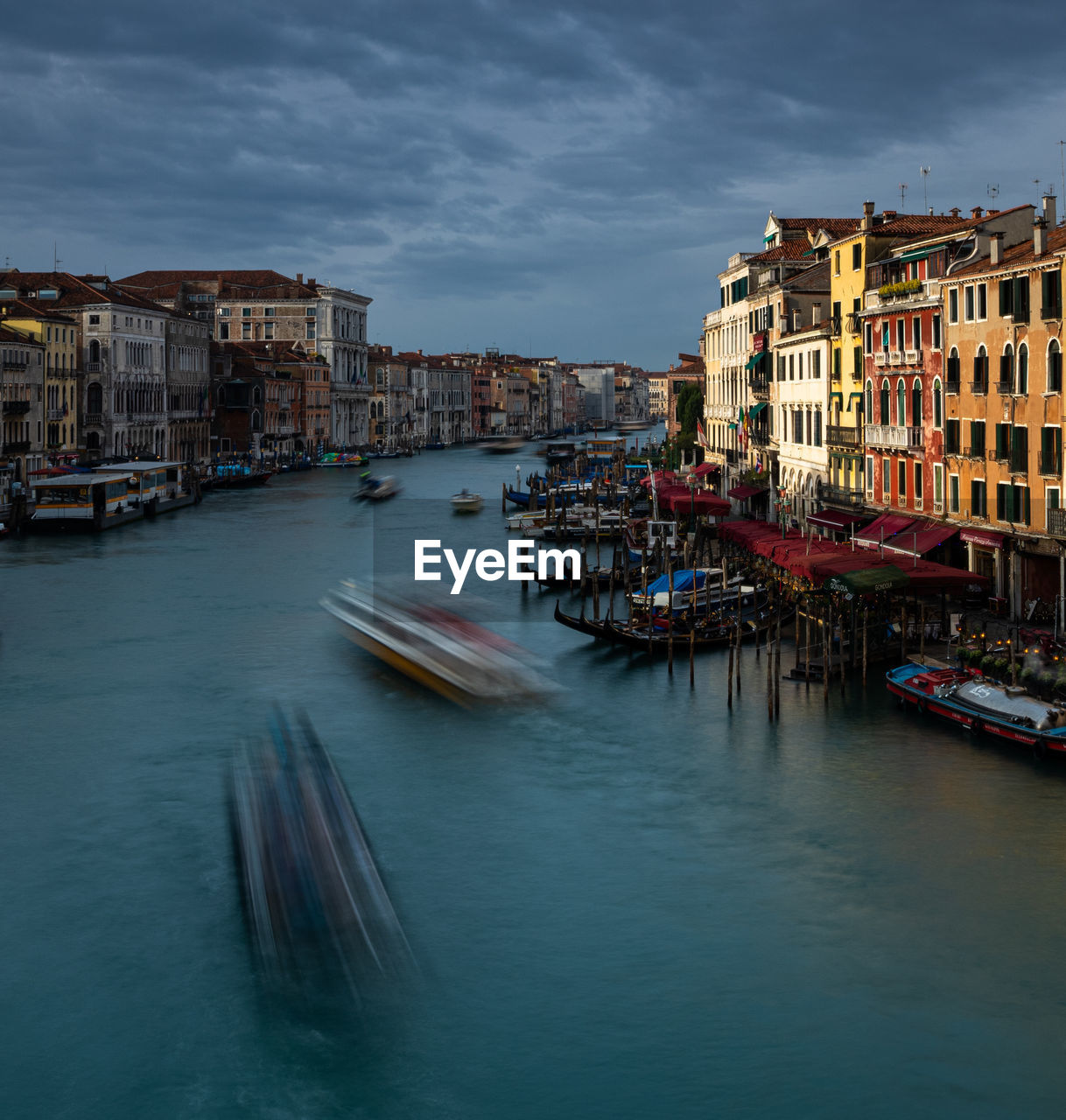 Canal amidst buildings in city against sky