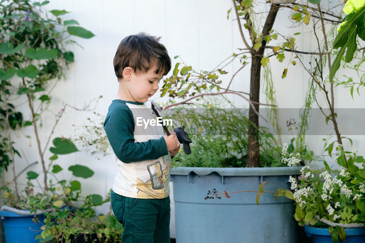 Boy playing with a stick in the garden