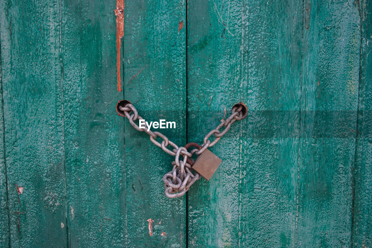 CLOSE-UP OF PADLOCKS ON METALLIC DOOR