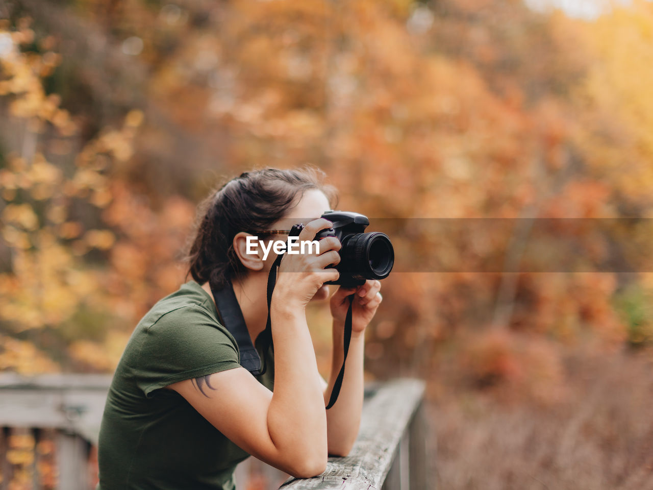 Woman photographing during autumn