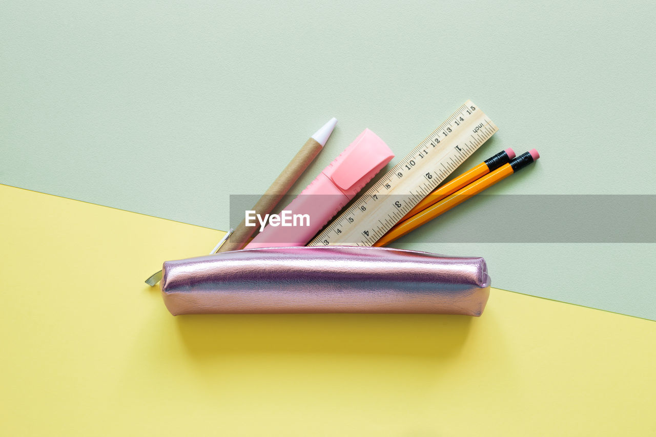 HIGH ANGLE VIEW OF COLORED PENCILS ON TABLE AGAINST GRAY BACKGROUND