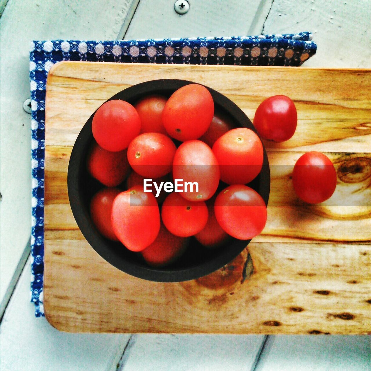 Bowl of tomatoes on cutting board