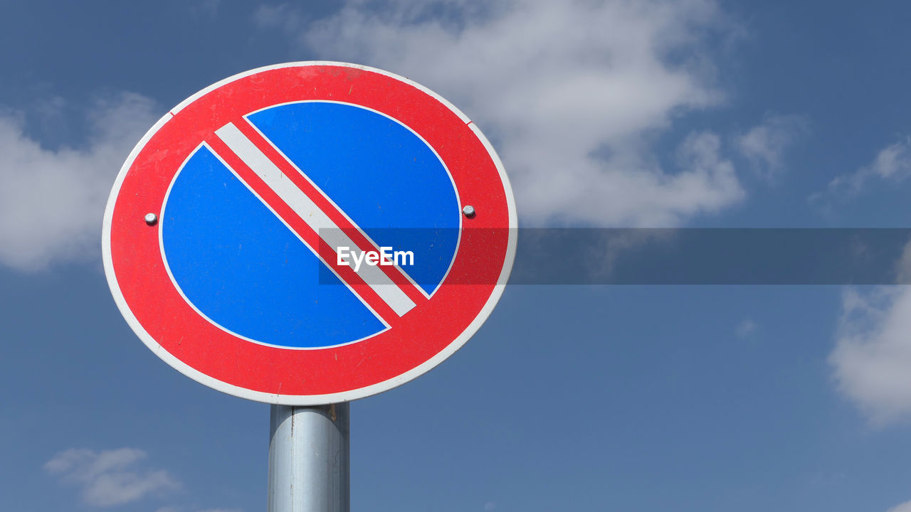 Road sign against cloudy sky