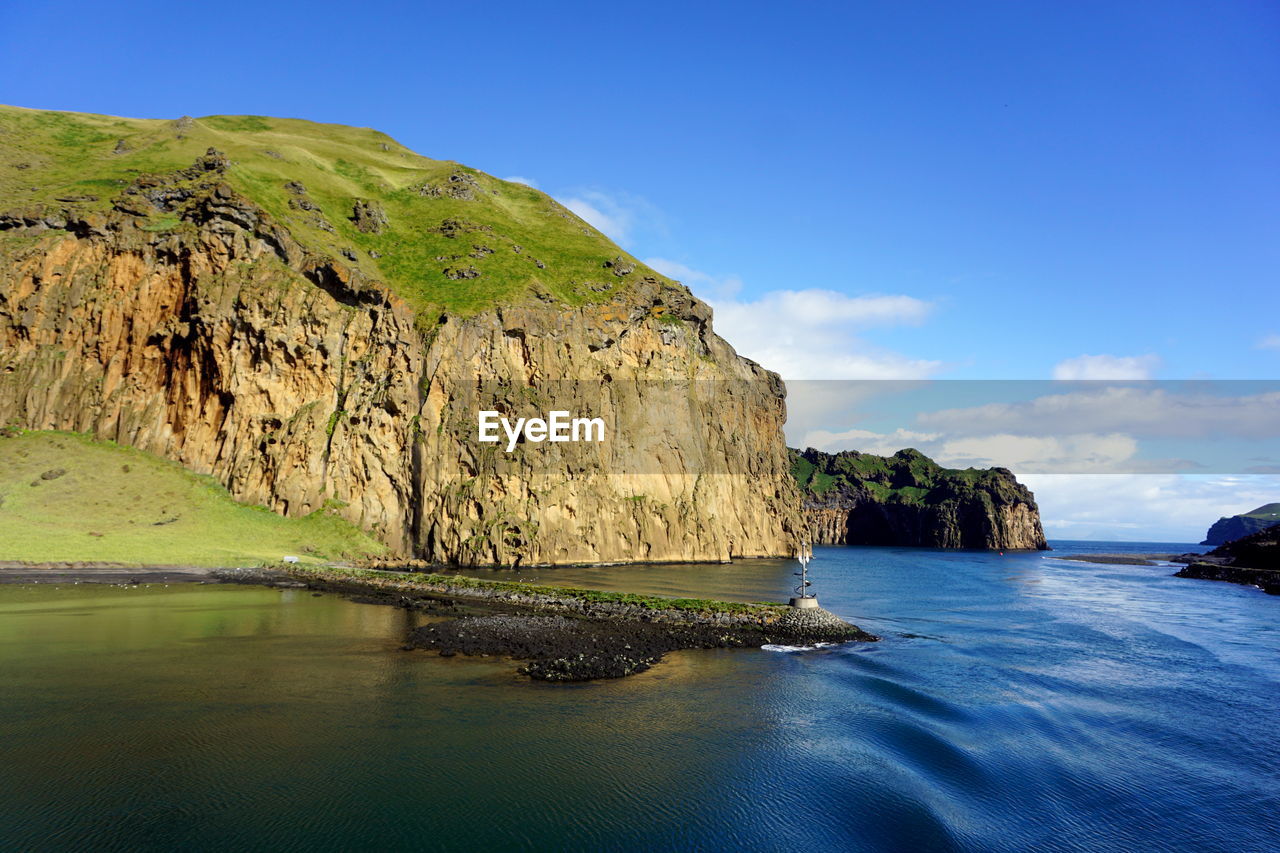 Scenic view of sea and mountains against sky