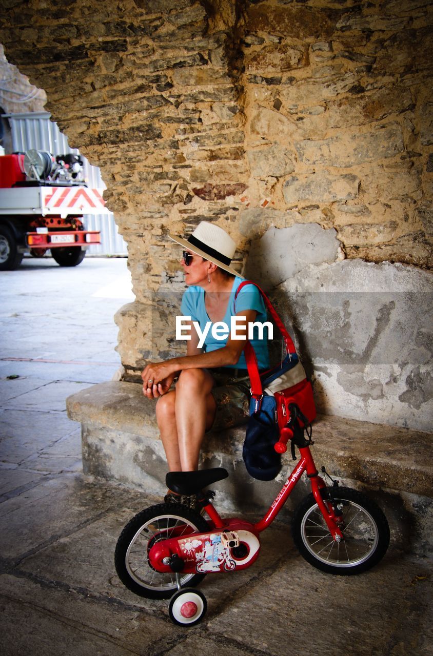 BOY SITTING AGAINST WALL