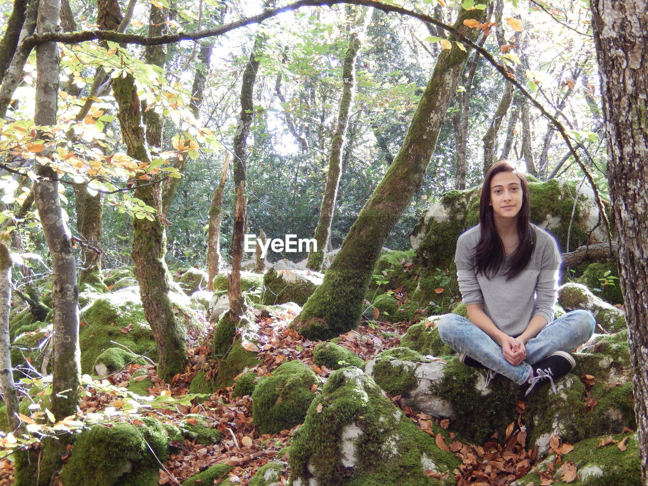 Portrait of young woman sitting on in forest