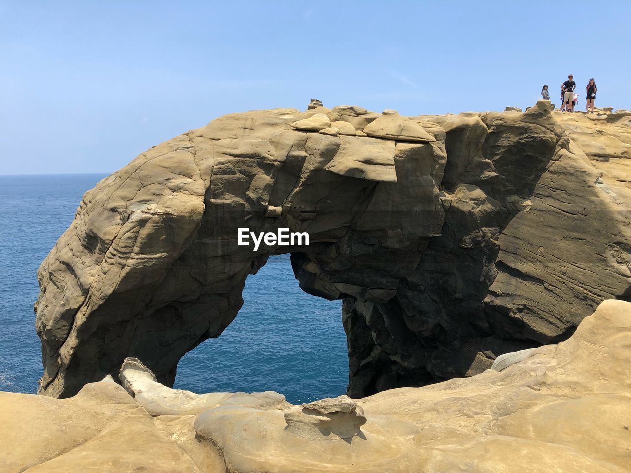 Rock formation on beach against sky