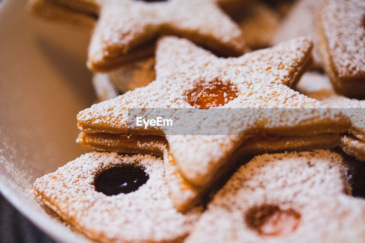 Close up of a star-shaped linzer cookie with marmalade and powdered sugar