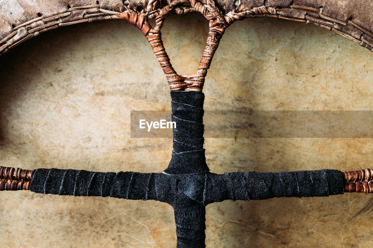 Close-up of tambourine with leather braided handle