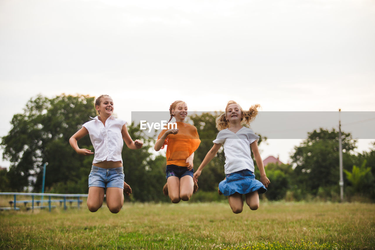 BOY RUNNING ON FIELD AGAINST SKY