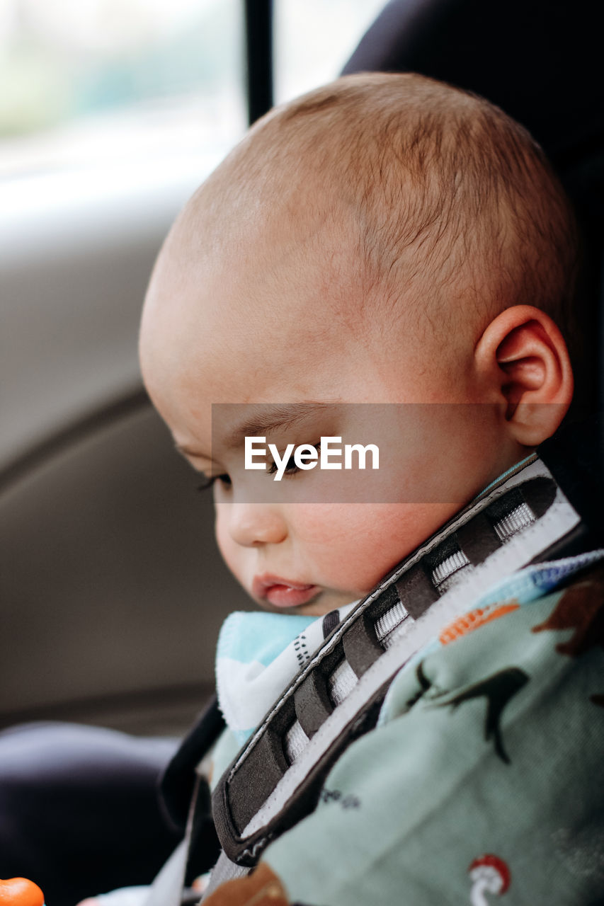 Sweet little baby boy in the car in baby safety seat