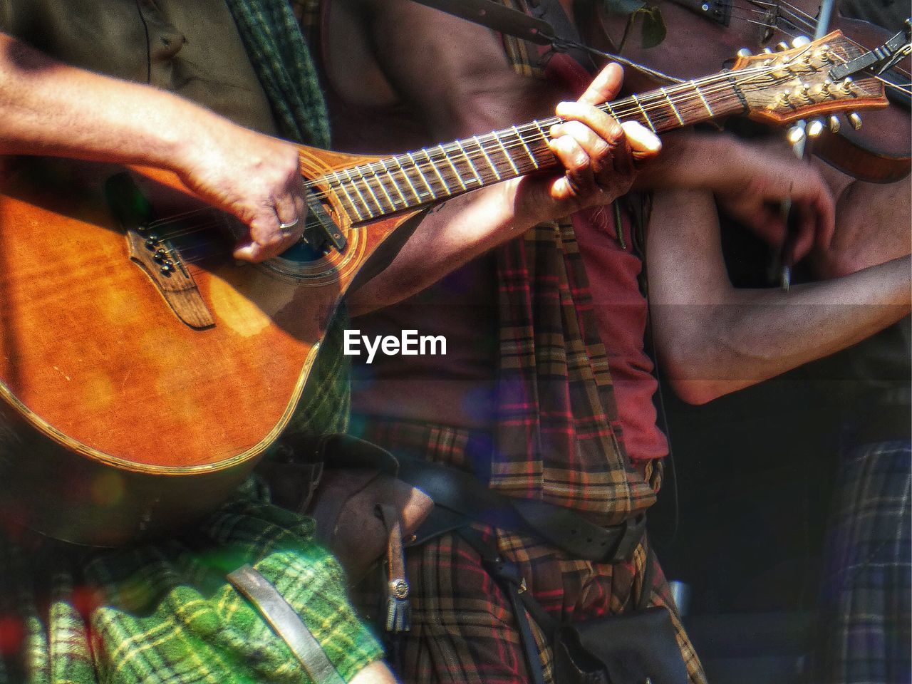 Midsection of men playing musical instruments at music concert