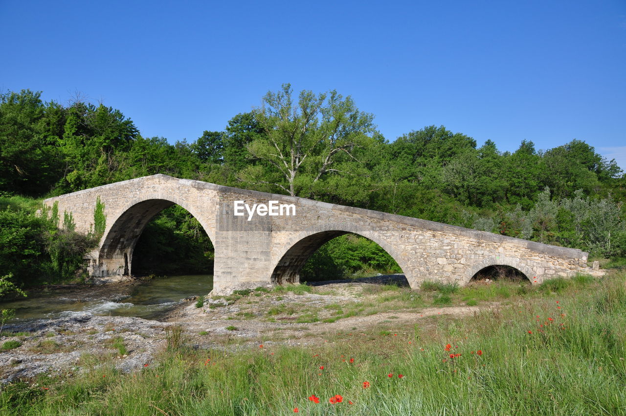 Arch bridge over river against sky