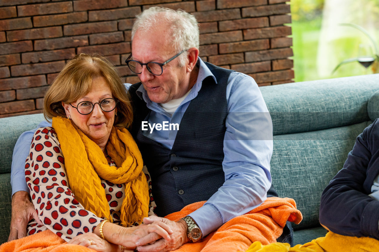 portrait of smiling friends sitting on sofa