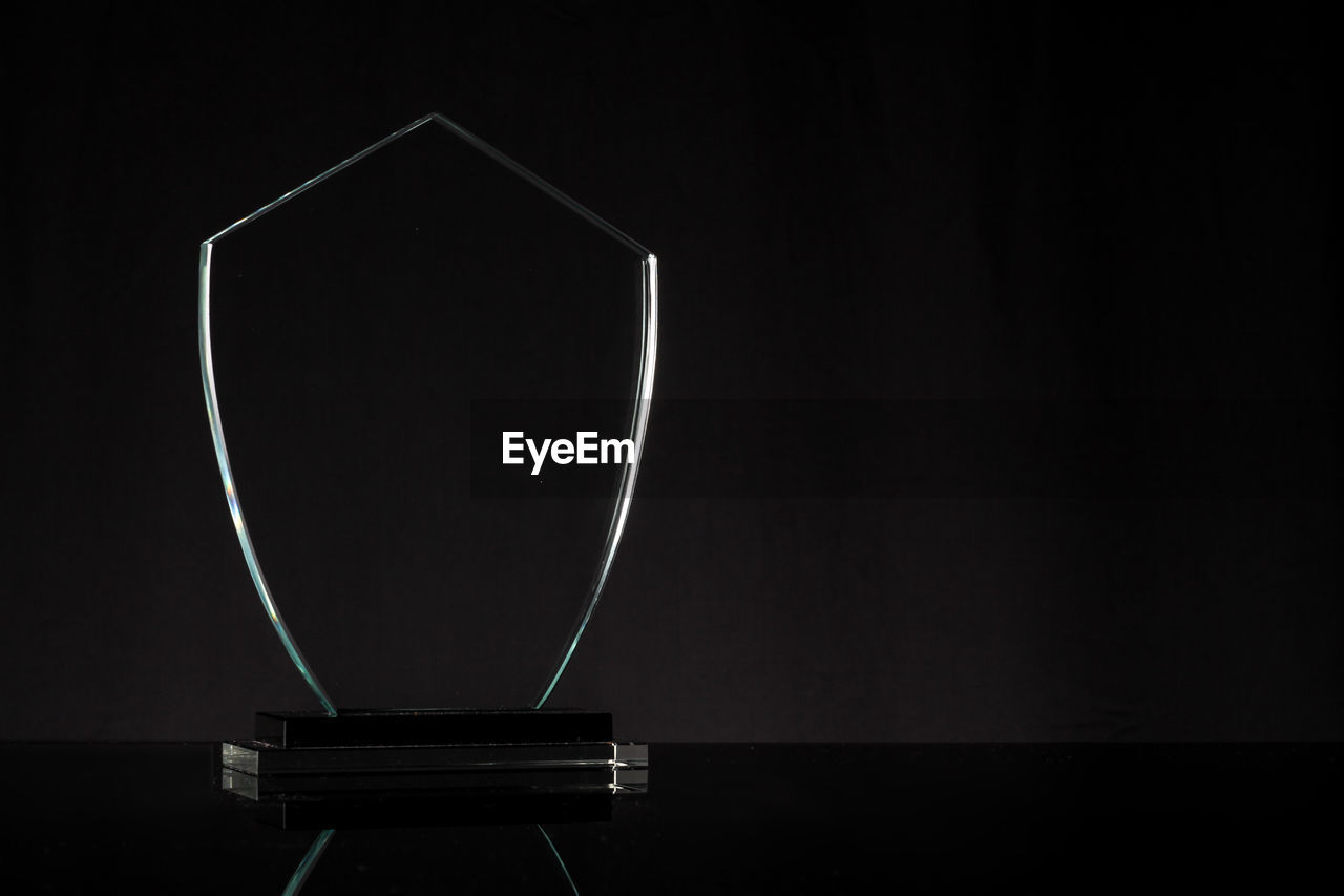 Close-up of shield on table against black background