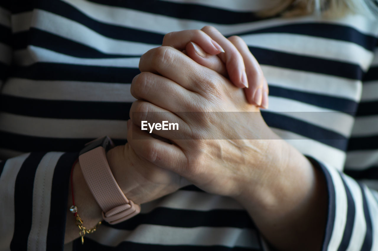 Midsection of woman with clasped hands