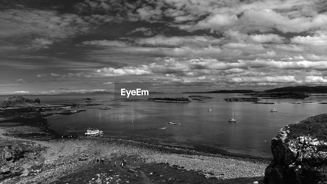 Idyllic view of sea against cloudy sky