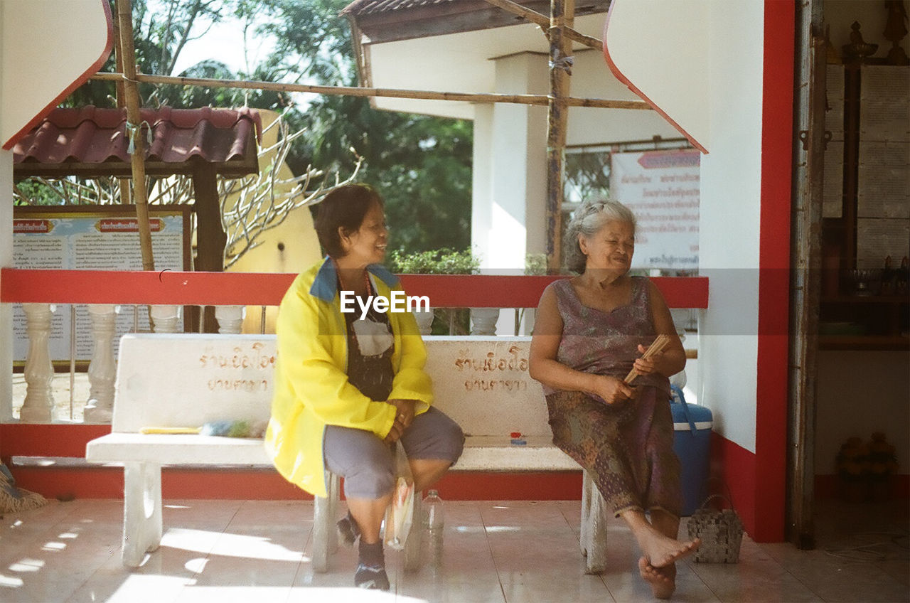 FULL LENGTH OF WOMAN SITTING AT AN ANIMAL