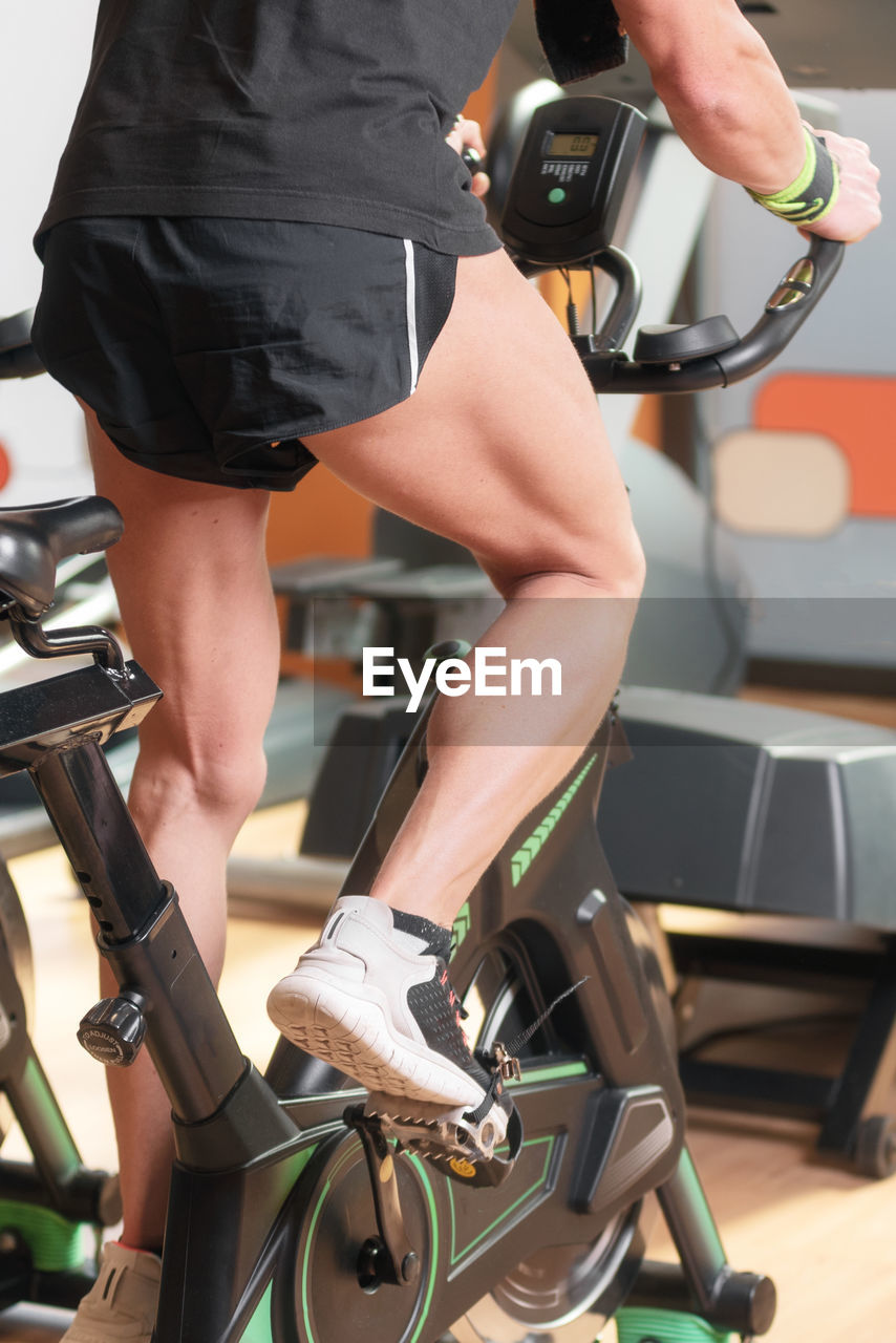 LOW SECTION OF MAN WITH BICYCLE ON SEAT IN OFFICE