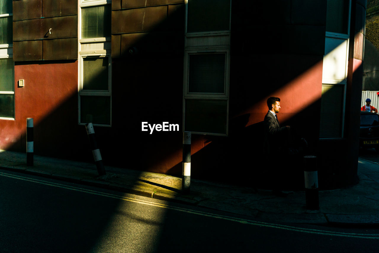 BLURRED MOTION OF MAN ON ILLUMINATED STREET