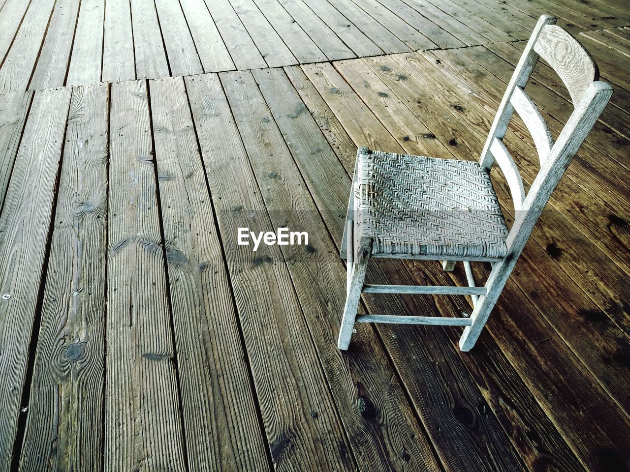 High angle view of white empty chair on boardwalk