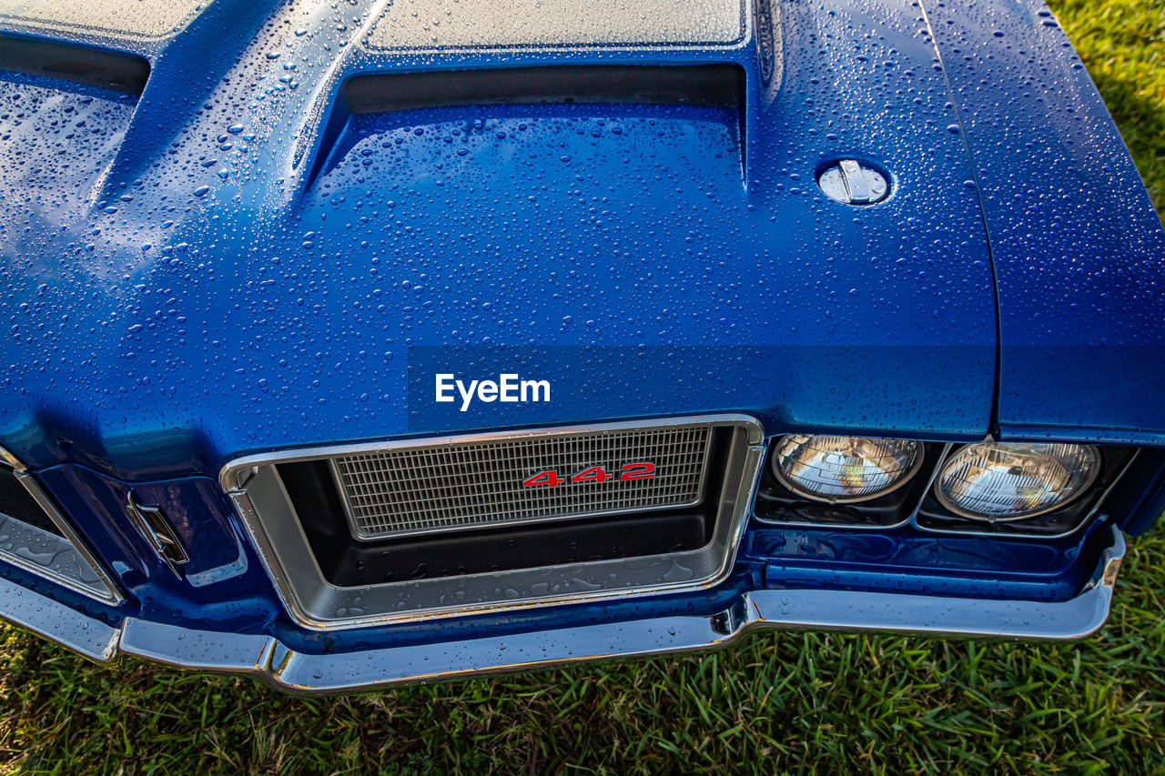 CLOSE-UP OF VINTAGE CAR ON BLUE METAL