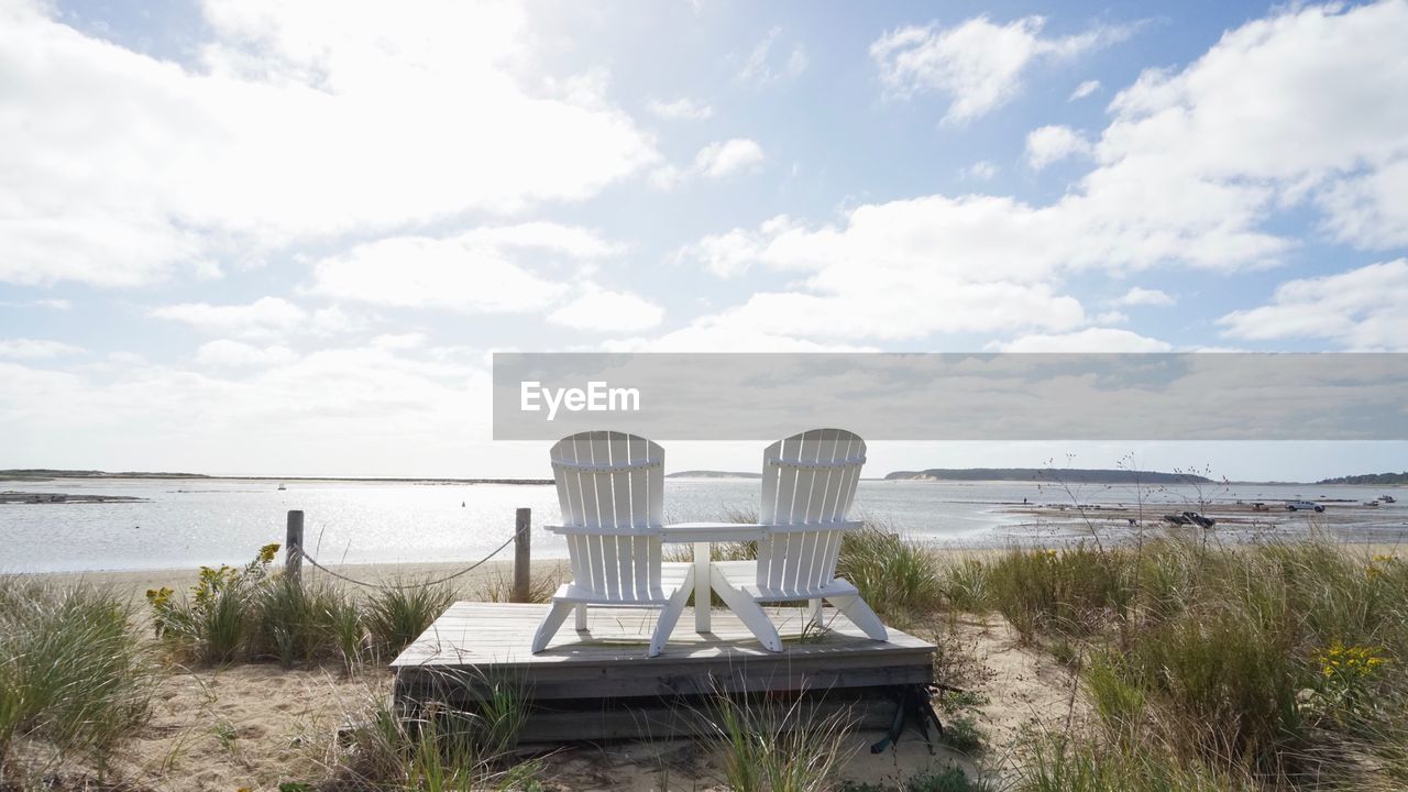 Chairs at beach against sky