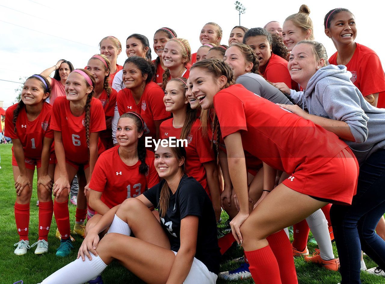 HIGH ANGLE VIEW OF FRIENDS STANDING ON SOCCER FIELD